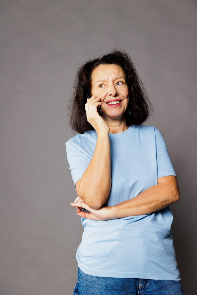 femme âgée souriante au téléphone