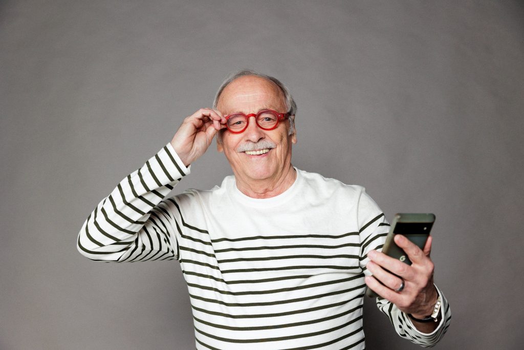 senior heureux en marinière avec des lunettes rouges