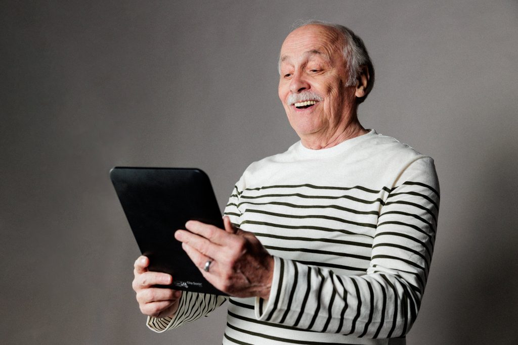 senior heureux devant sa tablette portable