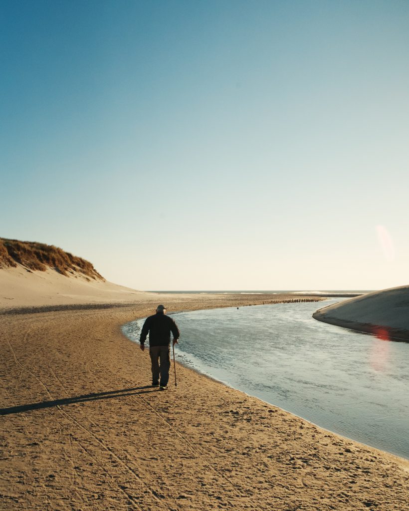 homme sur la plage marchant au soleil