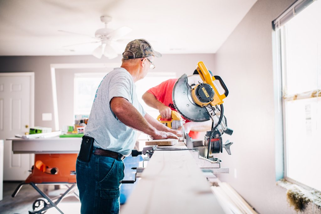 senior faisant des travaux chez lui avec des outils