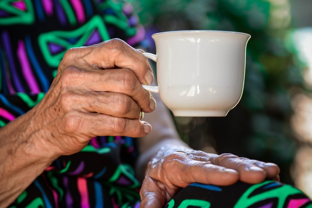 femme âgée tenant une tasse de café