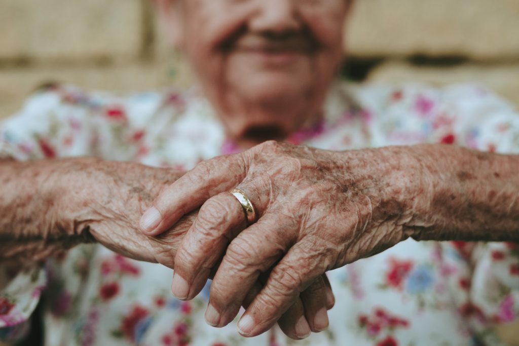 femme âgée souriante croisant les mains avec 