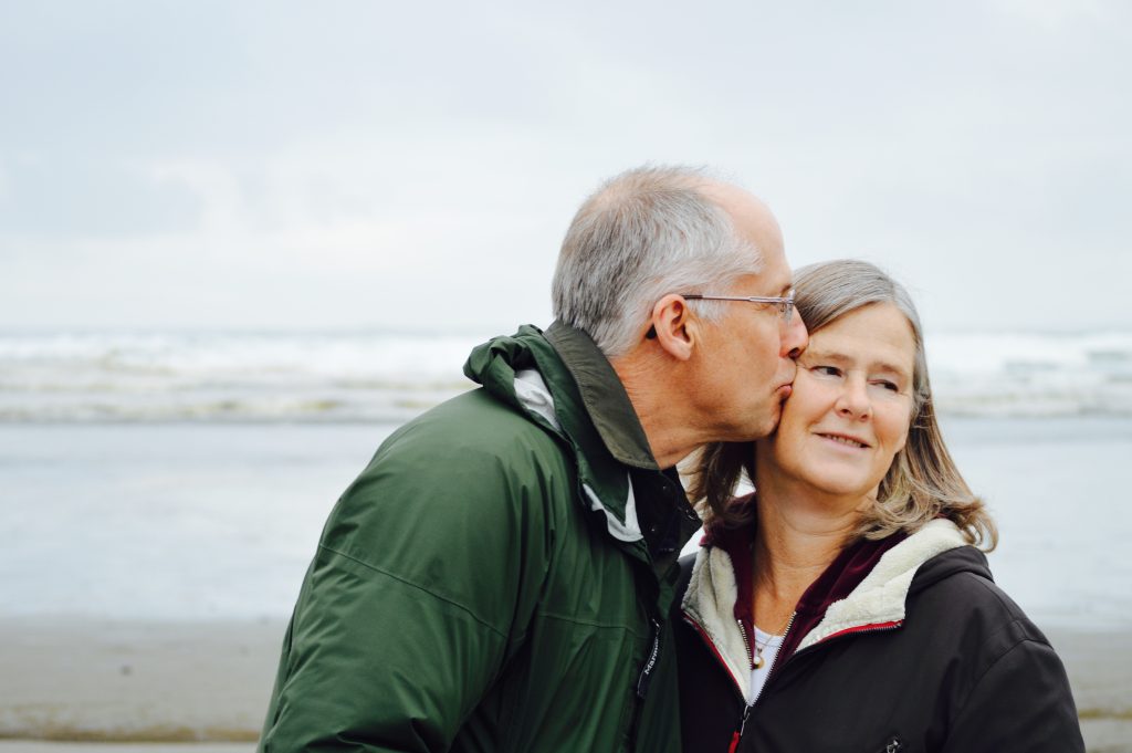 homme embrassant sa femme à la plage