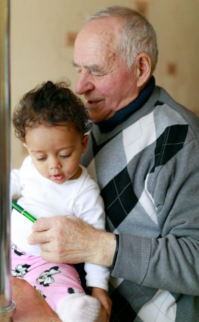 grand-père tenant son petit-fils dans les bras