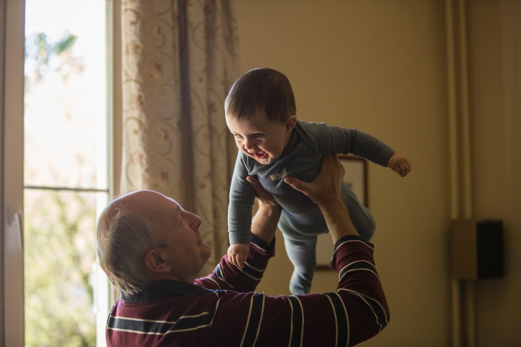 senior en train de soulever son petit enfant dans ses bras