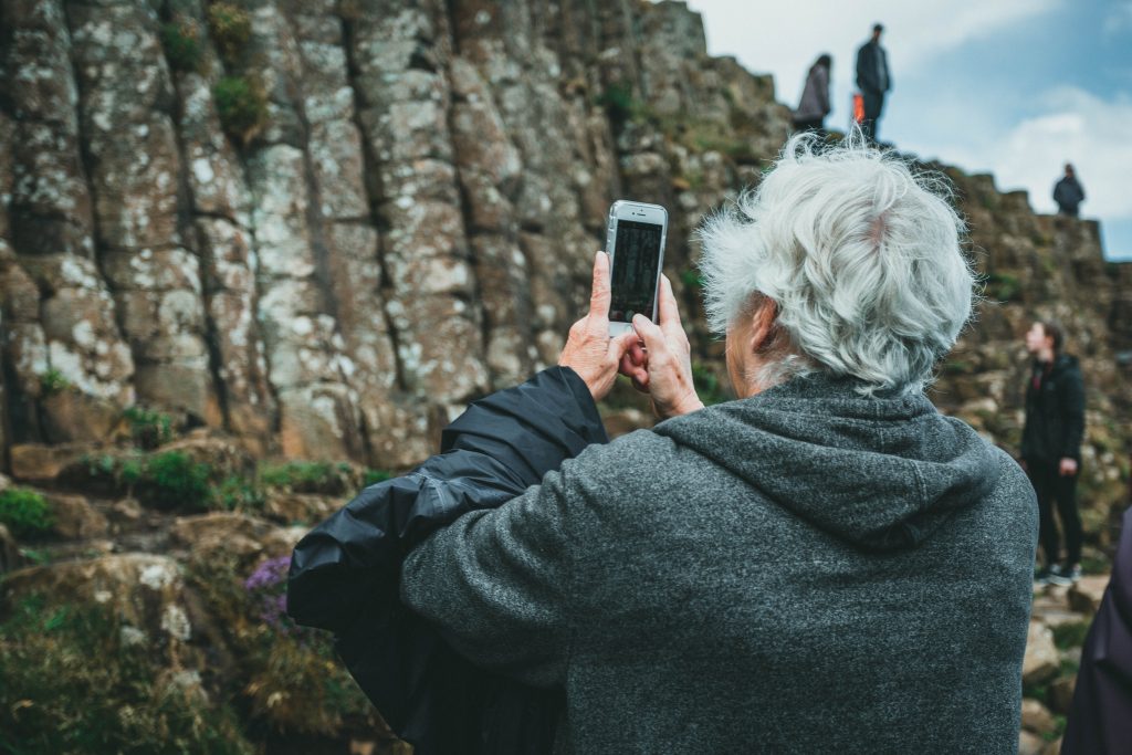 senior en train de prendre une photo avec son téléphone