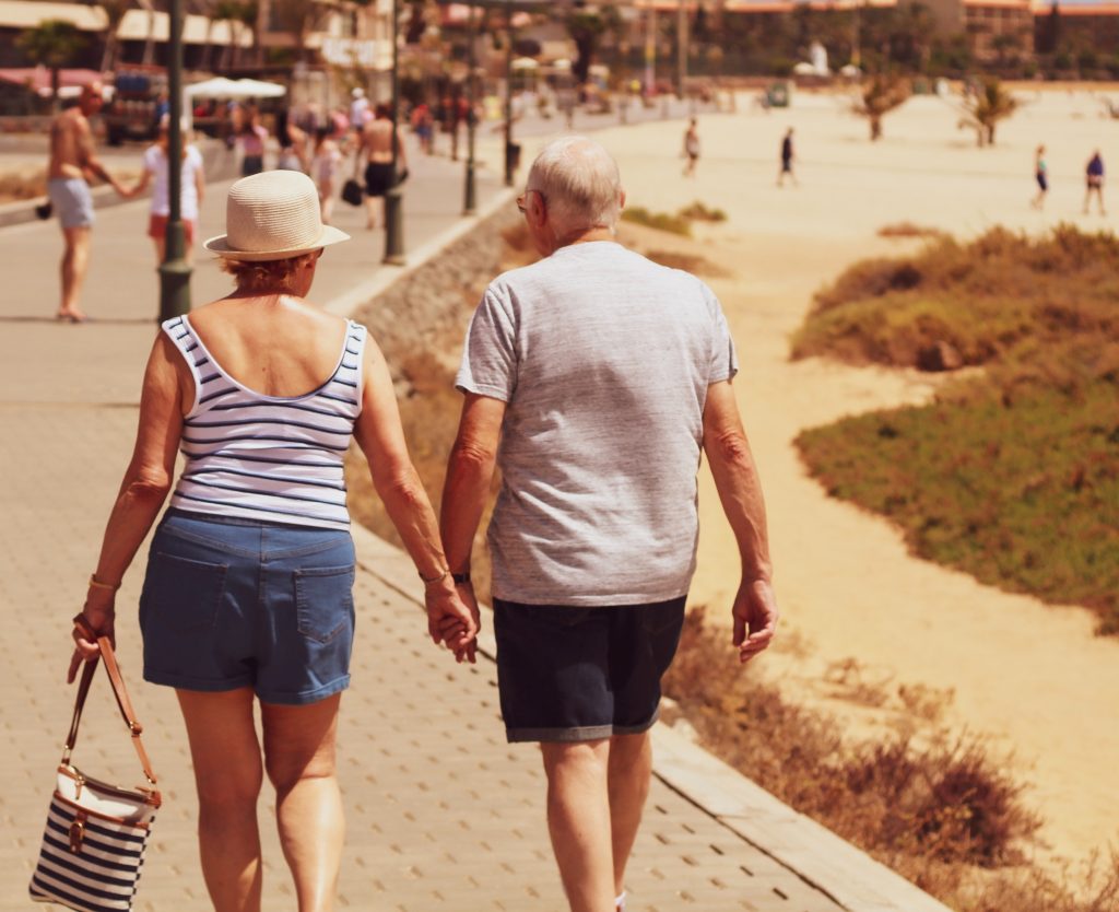 couple de seniors à la plage se tenant par la main