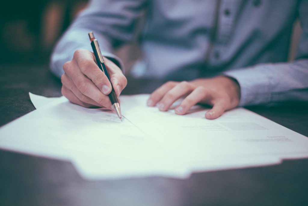 monsieur en train de signer des papiers